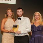 Two women and one man in formal dress accepting Business Green Award