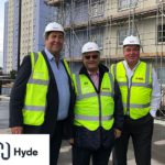 Three Axis people in high vis and hard hats on site with Hyde logo in corner